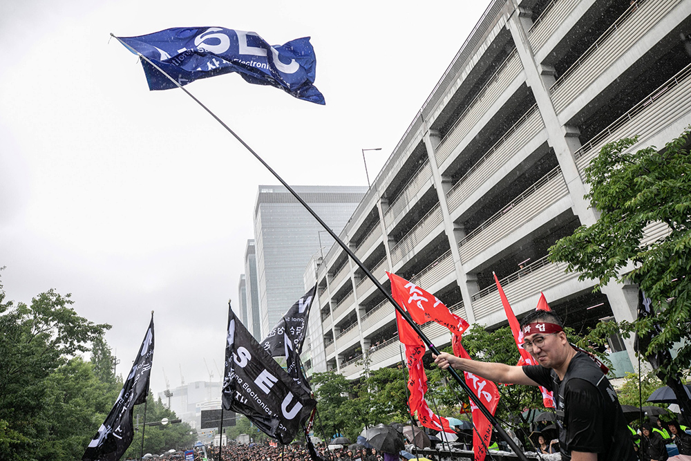 Strikers raise NSEU flags in front of Samsung plant